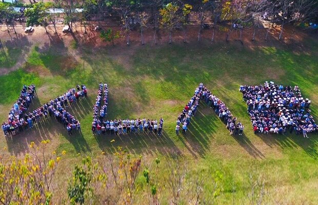 Group of people standing together forming the KLA logo.