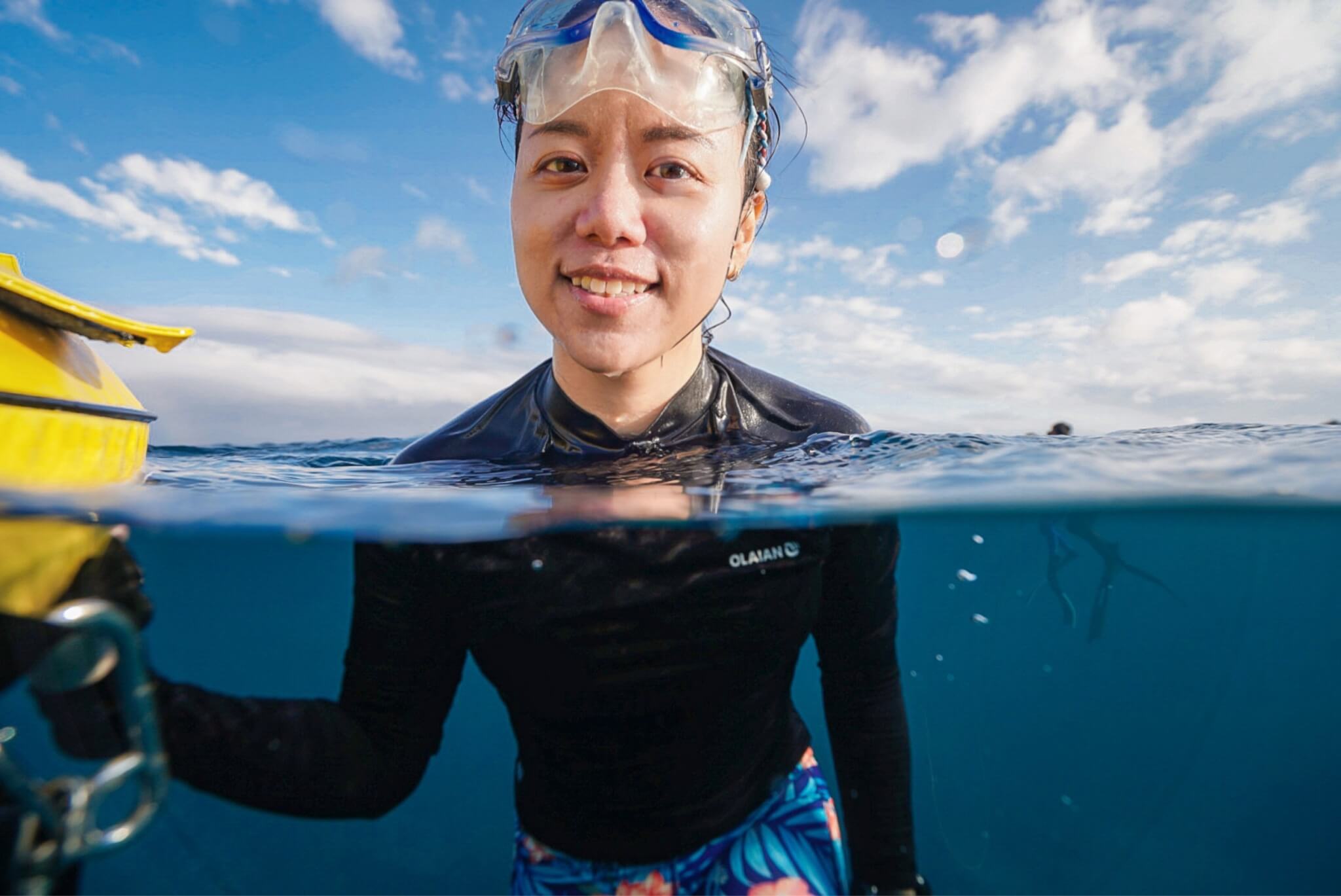 Image of June, a KLA employee, in the ocean with goggles and a wetsuit.